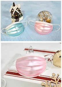 Dettaglio di ornamenti natalizi a forma di maschera perlata con bordi glitterati blu e rosa