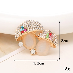 Colorful mushroom brooch with white and colored crystals on a gold alloy base
