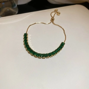Detail view of emerald green square crystal on adjustable gold-plated chain bracelet
