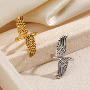 Minimalist adjustable angel wing rings in gold and silver finish on textured fabric