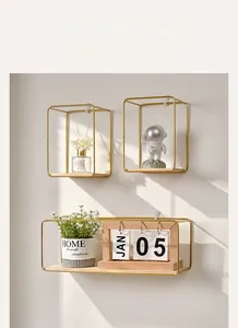 Close-up of golden metal wall shelves with wood base and decorative home accessories