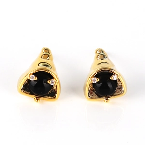 Detail of cone shaped gold stud earrings with black gemstone and clear rhinestones