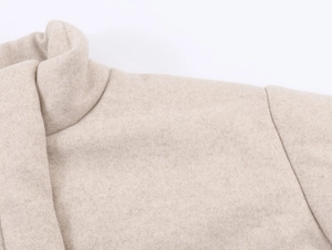 Detail view of the stand-up collar and wool texture on this beige women coat