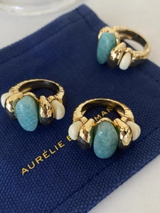 Detailed macro view of three vintage gold rings with amazonite stones on a blue pouch