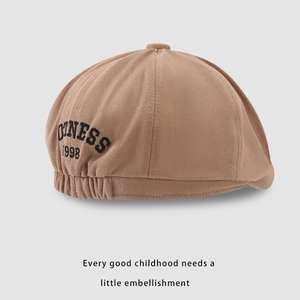 Detail of brown kids newsboy cap with black 1998 embroidery on premium twill fabric