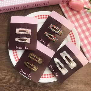 Cute pearl and rhinestone BB hair clips set for kids on a red checkered plate