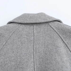 Detail of the high-quality grey wool coat showing collar texture and back shoulder stitching