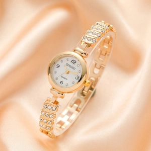Fashionable gold women's quartz watch with rhinestone bracelet on pink silk background