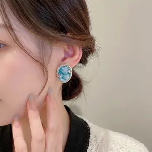 Vintage cameo oval stud earrings with pearl trim and colored crystals on model