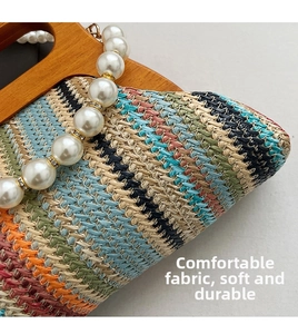 Detail of colorful striped woven handbag with wooden handle and faux pearl strap