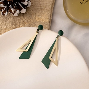 Minimalist green geometric triangle earrings with gold hollow frame on ceramic tray