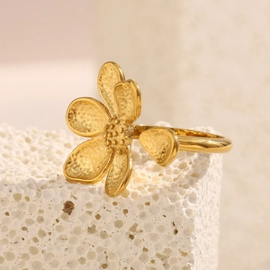 Detail of 18K gold flower ring with hammered texture petals and micro-bead center