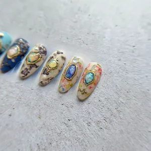 Detail of luxury 5D nail art stickers with vintage floral patterns and pearl ornaments