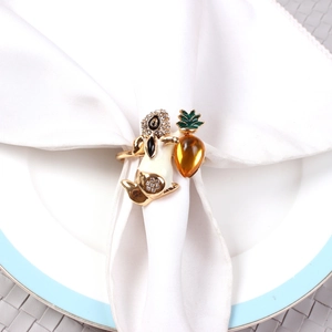 Detail of bunny napkin ring with gold metal, white enamel, and amber gemstone rabbit motif