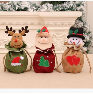 Détail de trois sacs cadeaux de Noël en tricot avec des motifs de renne et de Père Noël