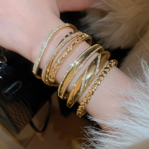 Detail of 18k gold plated bracelets with zircon inlay worn on wrist with luxury finish