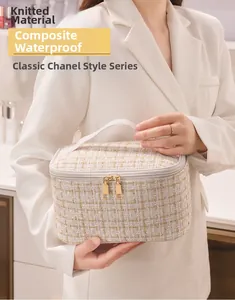 Detail of cream-colored tweed makeup bag with waterproof warp knitted fabric and gold thread