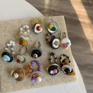 Artistic beaded rings set on stone tray featuring vintage hearts and mixed materials