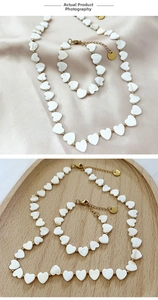 Detail view of heart-shaped shell necklace and bracelet set with golden beads and clasps