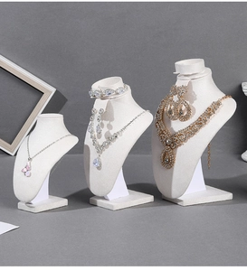 Macro view of velvet bust jewelry stands displaying necklace and earring sets in a row