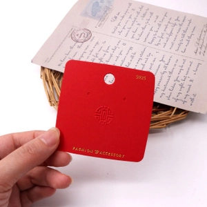 Close-up of red cardboard jewelry display tag for S925 earrings and necklaces