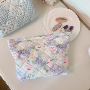 Detailed macro shot of the quilted cotton floral makeup bag with a secure zipper closure