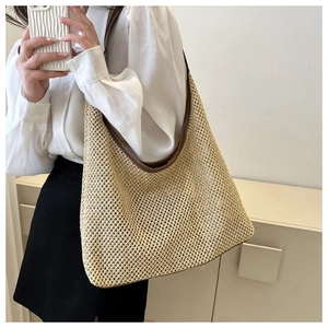 Detail showing natural straw weave texture with brown leather trim on a summer tote bag