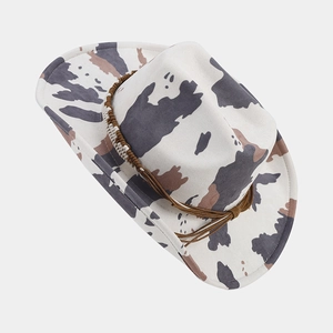 Detailed view of western cow print felt cowboy hat with brown braided trim and wide brim