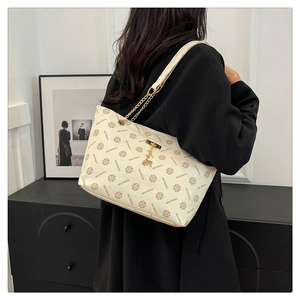 Detail of vintage monogram tote with gold chain strap and deer pendant on model
