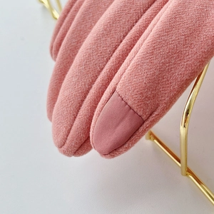 Primer plano de guantes térmicos rosas de invierno con puntas táctiles y tejido de punto suave
