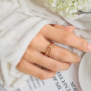 Close-up of a stylish gold knot ring on finger with elegant lifestyle background décor