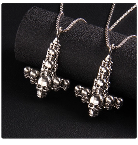 Detailed close-up of a pair of silver skull pendants on a dark textured background