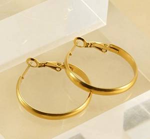 Detail view of gold hoop earrings on an acrylic stand with spring clasp closure