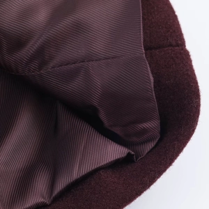 Detail shot of wine red wool coat fabric with premium striped polyester lining