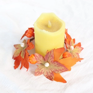 Detail of fall candle ring featuring orange maple leaves, pumpkins, and white pearls