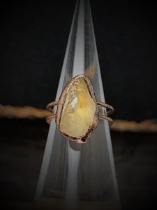 Macro shot of natural yellow raw gemstone on vintage copper adjustable ring