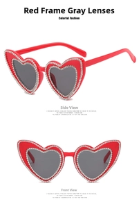 Macro shot of heart-shaped sunglasses with red frame, grey lenses and double-row rhinestones