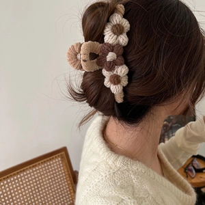 Macro detail of plush floral hair claw clip in beige and brown on model's hair