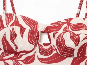 Detailed view of red and white leaf print fabric with central cutout on a midi dress
