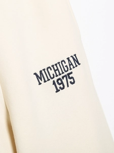 Gros plan détaillé de la broderie marine MICHIGAN 1975 sur un tissu de sweat-shirt beige