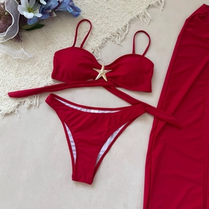 Détail de l'ensemble bikini rouge avec jupe en mesh et accessoire en forme d'étoile de mer