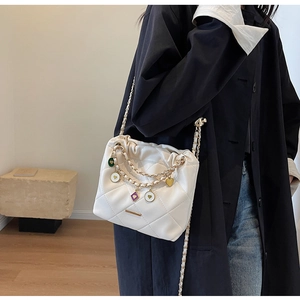 Sac seau matelassé blanc cassé avec bandoulière chaîne dorée et breloque en émail cœur