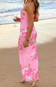 Détail d'une robe bustier rose à imprimé fleuri avec des fronces sur une plage en été