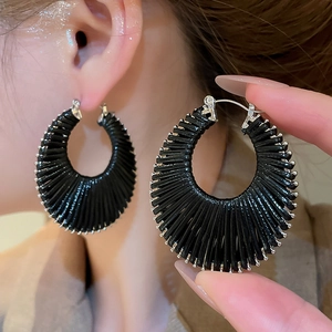 Vue détaillée de boucles d'oreilles noires tissées avec perles argentées sur mannequin