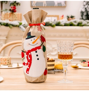 Détail du cache-bouteille de Noël en toile de jute avec broderie bonhomme de neige et ruban