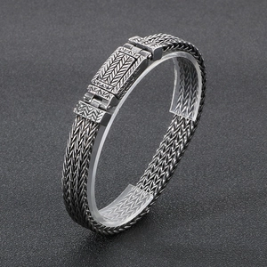 Macro shot of silver stainless steel wheat pattern punk bracelet with engraved box clasp