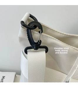 Close-up of durable black mountain buckle hook on white canvas shoulder strap