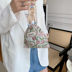 Pink tulip floral drawstring pouch held by a model for organizing cosmetics and small items