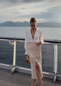 Détail d'une jupe longue beige au crochet avec fente haute et dentelle ajourée élégante