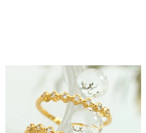 Detailed macro of 18K gold plated wavy zigzag ring with sparkling white zirconia stones